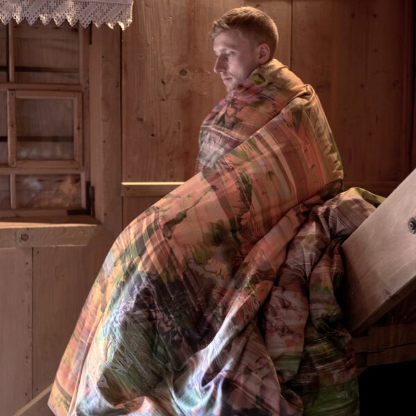 man in duvet on stairs